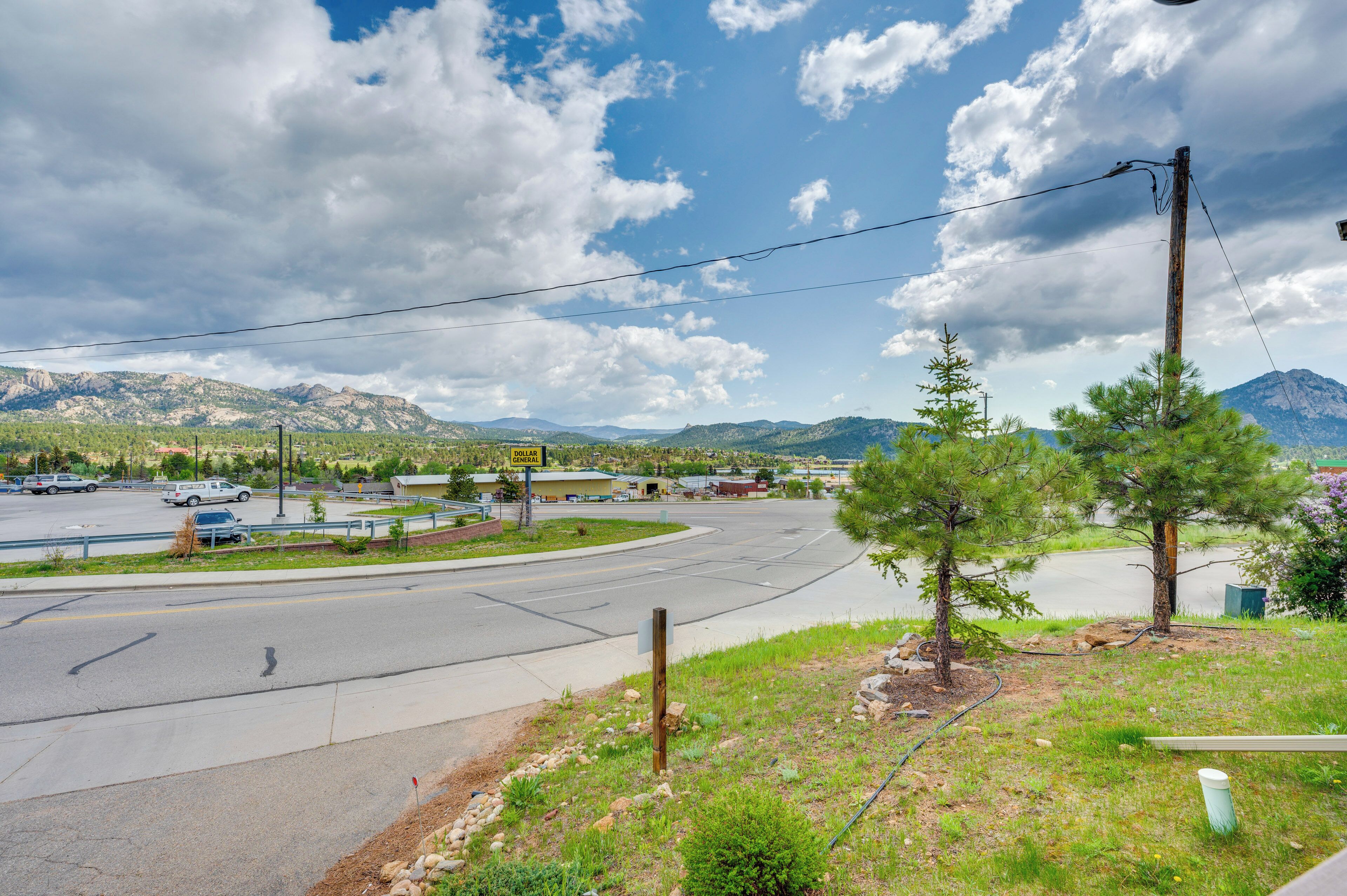 Eine kurvenreiche Straße, im Hintergrund ein Gebirge und ein Schild von Dollar Tree.