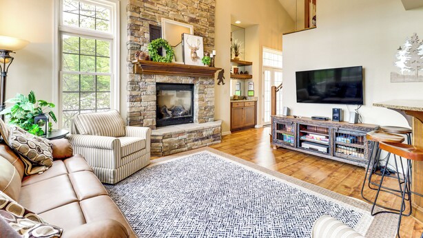 Un salón amplio con chimenea de piedra, un televisor grande y una zona de estar confortable.