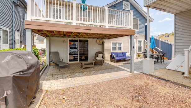 A covered patio area with a barbecue grill, outdoor seating, and a covered deck. - Steps to Sand & Boardwalk! Seaside Heights Condo (Seaside Heights)