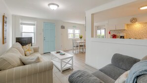 A living room with a sofa, a coffee table, and a dining area with a table and chairs. - Steps to Sand & Boardwalk! Seaside Heights Condo (Seaside Heights)