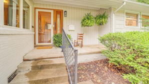 A house with a front porch, a wooden door, a small seating area, and a window. - 6 Mi to Dtwn: Waterfront Home in Tulsa! (Tulsa)