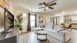 Ein modernes Wohnzimmer mit einer Couch, einem Couchtisch und einem Deckenventilator.
