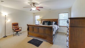 A bedroom with a wooden bed, a ceiling fan, a floor lamp, and a dresser. - 7 Mi to Downtown Baytown: Spacious Home w/ Yard (Baytown)