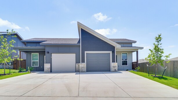 A modern two-story house with a garage, a sloped roof, and a well-maintained lawn. - 2 Mi to Dtwn Dining! Pet-friendly Temple Townhome (Temple)