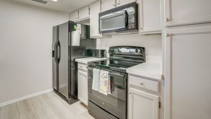 A modern kitchen with stainless steel appliances, white cabinetry, and a skylight. - Patio + Pool Access: Golf Getaway in Peoria (Peoria)