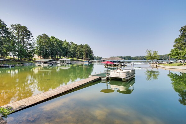A calm lake with a dock, boats, and a covered area. - < 1 Mi to Marina: Fair Play Home on Lake Hartwell (Fair Play)
