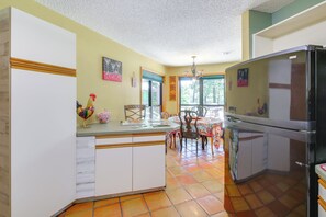 A kitchen with a central island, a dining area with chairs and a table, and a refrigerator. - Secluded Lake Hamilton Access: Hot Springs Home (Hot Springs)