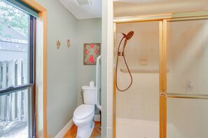 A bathroom with a toilet, a shower, and a window. - Secluded Lake Hamilton Access: Hot Springs Home (Hot Springs)