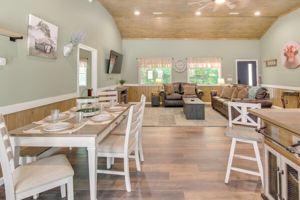 A spacious living area with a dining table set for four, a sofa, and a bar area. - 15 Mi to Pigeon River Rafting: Newly Built Cabin! (Newport)
