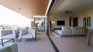 A modern living room with a sofa, chairs, and a dining area. - Marina Garden 2 Bedroom Apartment With Picuzzi (Punta Cana)