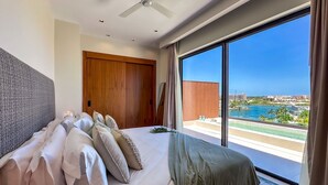 Un dormitorio moderno con una cama grande, un armario de madera y vistas a la costa.