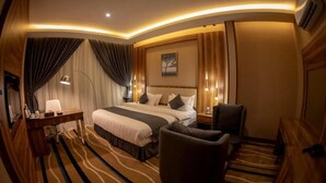 Habitación de hotel con una cama grande, un escritorio, una silla y un espejo amplio.
