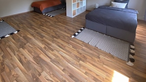 Een slaapkamer met twee bedden, een wit wandrek en een plafondventilator.