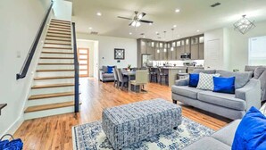 A spacious living area with a staircase, a dining area, and a kitchen.