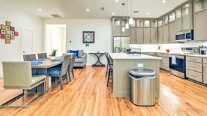 A modern kitchen with grey cabinets, stainless steel appliances, and a central island.