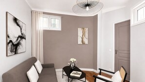 A modern living room with a sofa, a coffee table, and a chair. There are two artworks on the walls, a window with curtains, and a door. - 1611 Vouillé (Paris)
