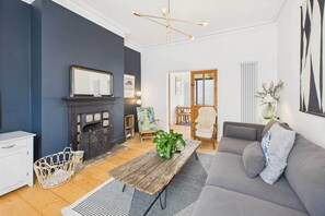 A living room with a fireplace, a sofa, a coffee table, and a chair.