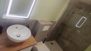 A modern bathroom with a round sink, a mirror, a toilet, and a shower. - Maison Réthaise 1 city center Garden mix art/flowers (LA FLOTTE)
