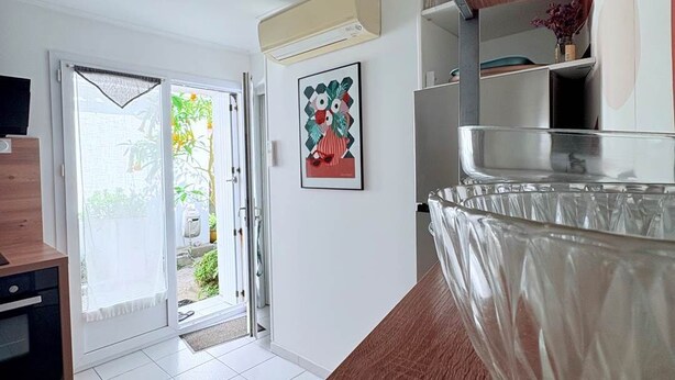 Una cocina moderna con encimera de madera, un bol de vidrio y una puerta que da a un jardín.