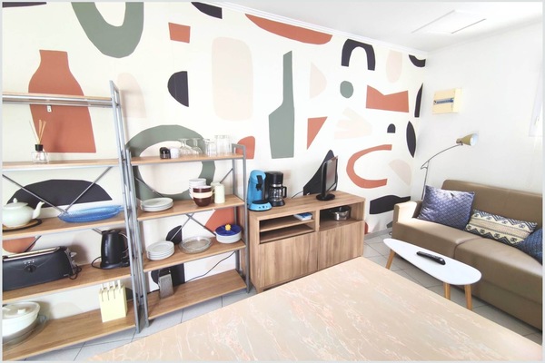 Maison Réthaise 2 – Séjour cosy et graphique Ambiance contemporaine dans un espace bien agencé, parfait pour savourer des moments de détente en centre-ville.