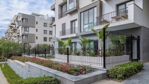 A modern apartment building with balconies, a landscaped garden, and a paved walkway. - Kennah Rivera | 2BR Garden Apt, Near EDNC Mall (New Cairo)