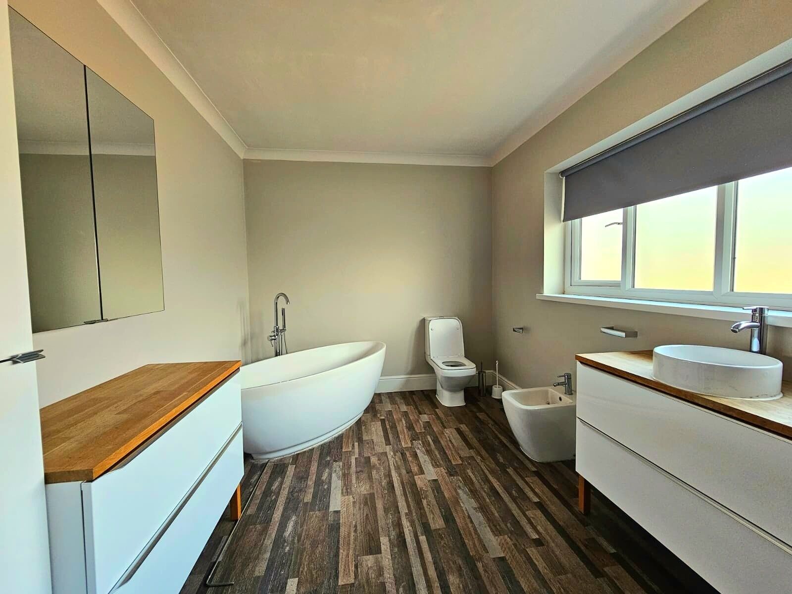 Un baño moderno con una bañera independiente, inodoro, bidé y lavamanos.