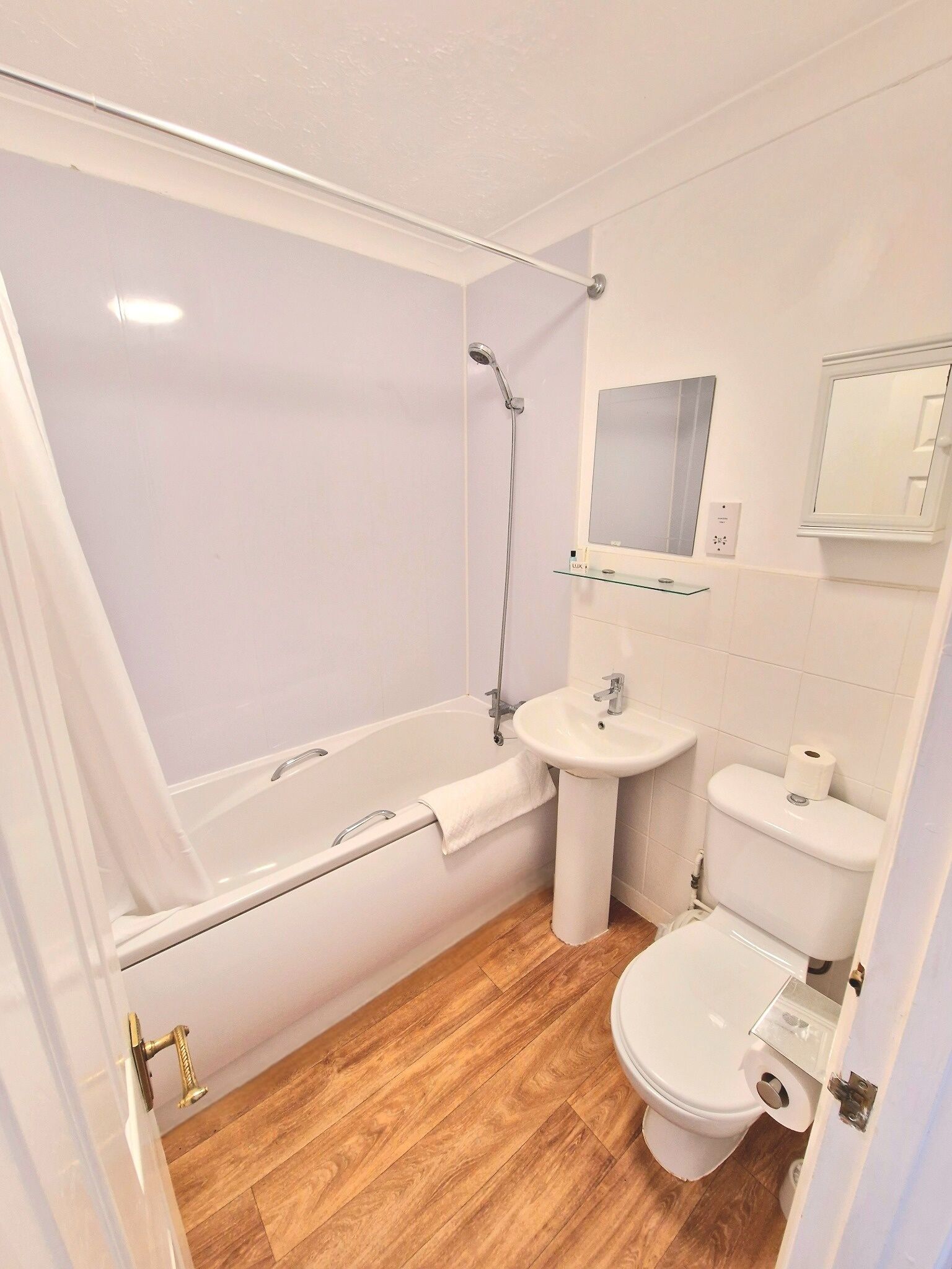 Une salle de bain avec une baignoire, un lavabo, des toilettes et un miroir.