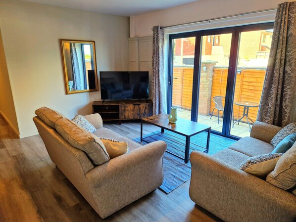 A living room with a sofa, a coffee table, and a TV on a wooden cabinet.