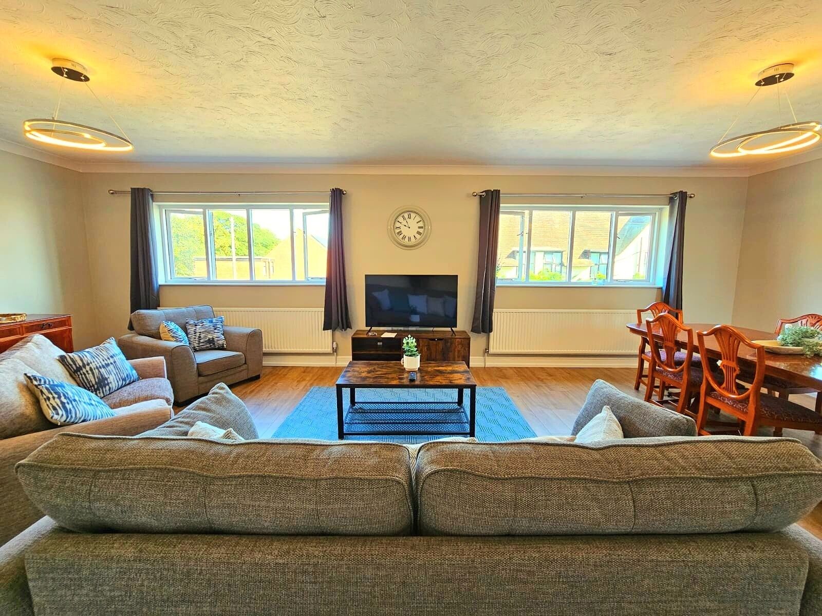 Ein Wohnzimmer mit einer Couch, einem Fernseher und einem Esstisch.
