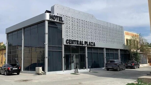 A modern hotel with a large glass facade and a sign reading "HOTEL CENTRAL PLAZA". - Central Plaza (Urgench)