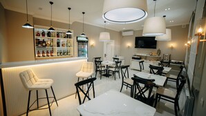 A modern bar area with a counter, bar stools, and a selection of liquor bottles. - Central Plaza (Urgench)