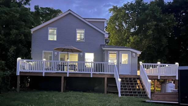 A two-story house with a deck and a covered patio area.