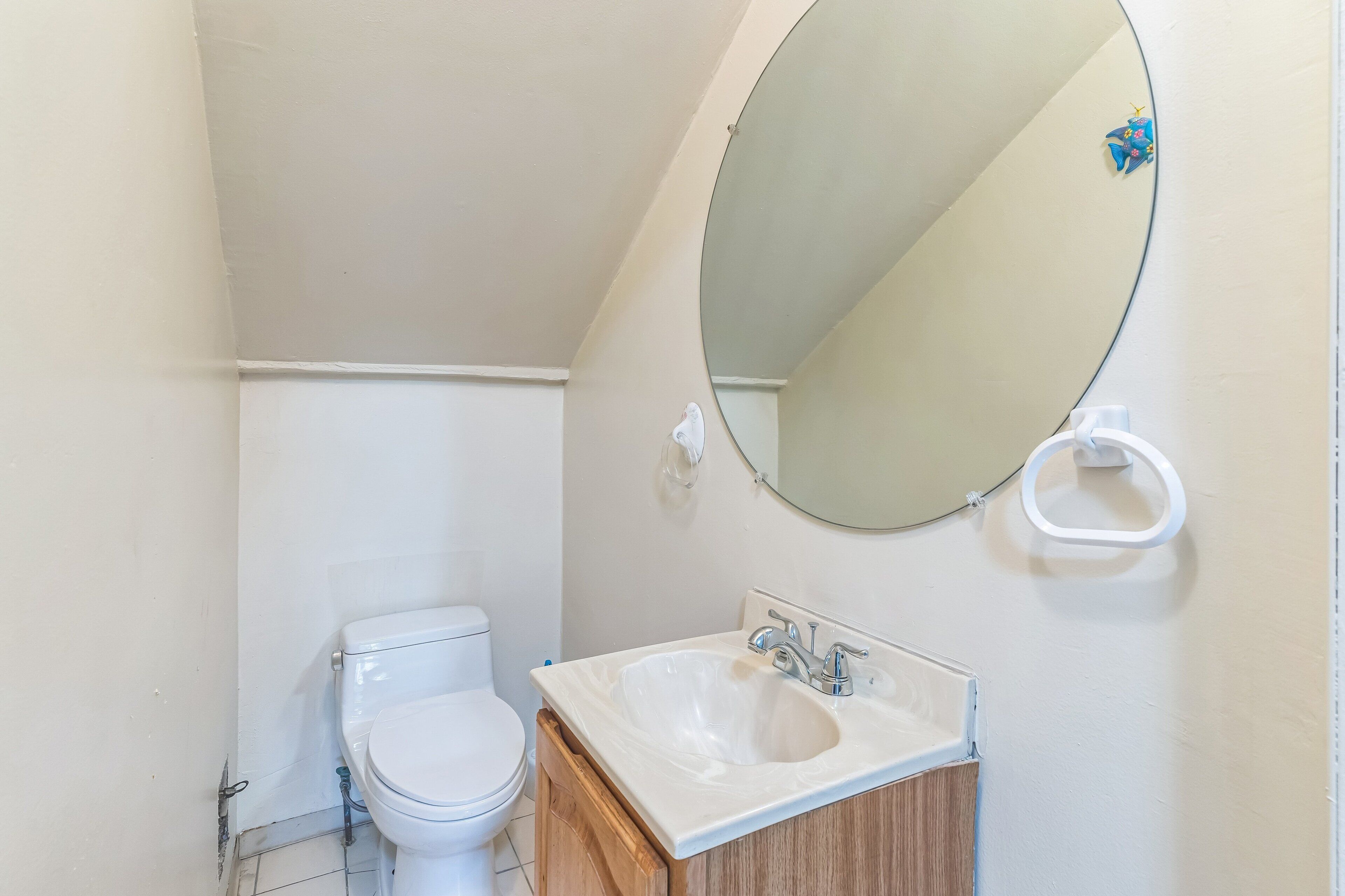Un baño con inodoro, lavamanos y espejo.