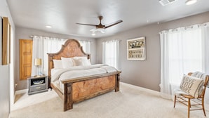A bedroom with a wooden bed, a nightstand, a chair, and a ceiling fan. - Peaceful Horse Ranch Escape Near Palo Duro Canyon 3 Bedroom Home (Canyon)