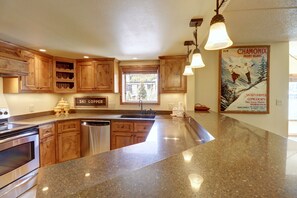 A kitchen with wooden cabinets, granite countertops, a dishwasher, and a sign that says "SKI COPPER". - Wl210 West Lake Lodge 2 Bedroom Condo (Copper Mountain)