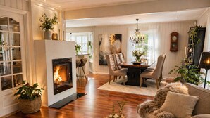A cozy living room with a fireplace, a dining area, and a sofa. - Detached house with terraces and garden. Close to the sea and the town center (Svelvik)