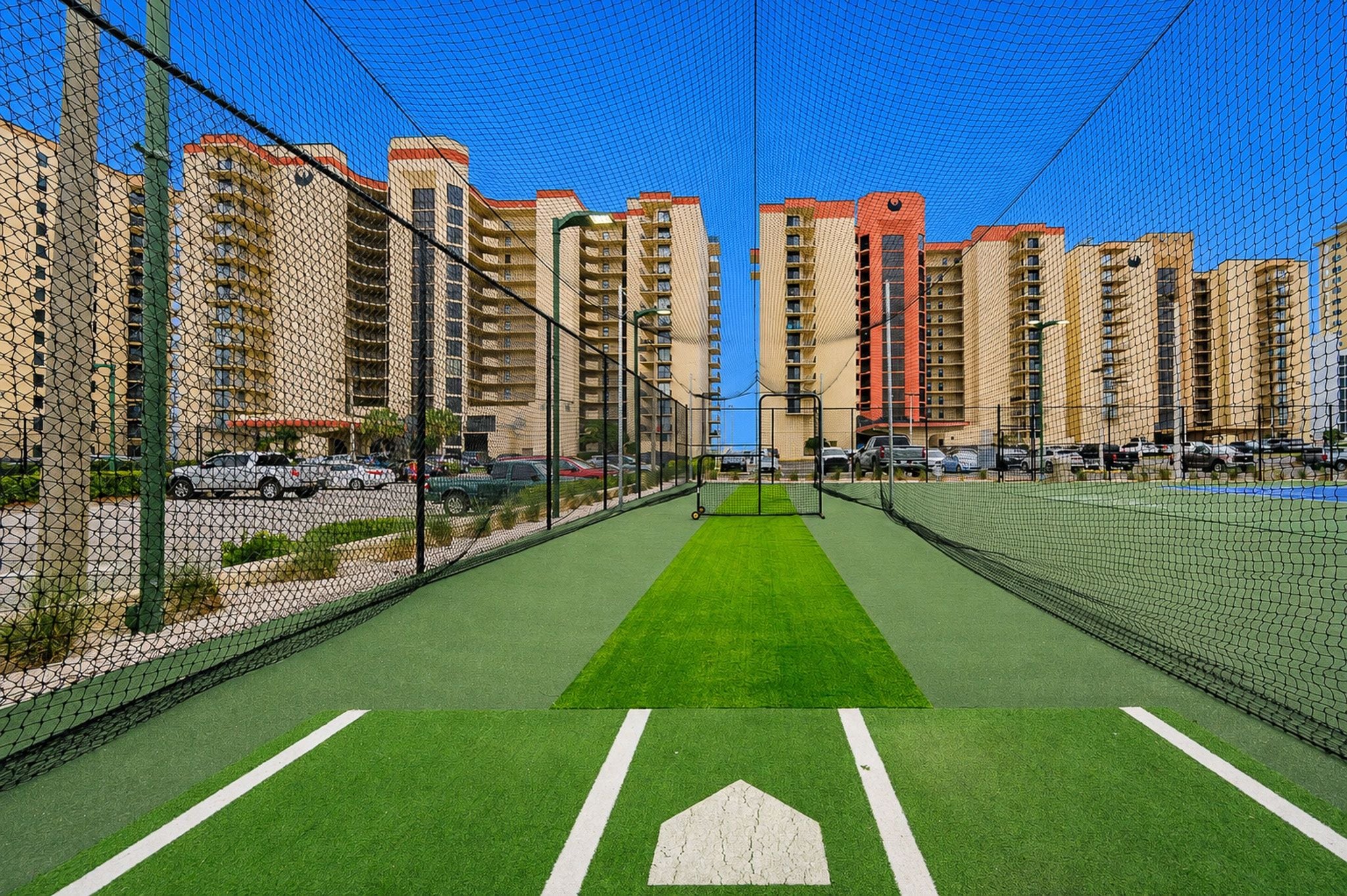 A sports court with a net, surrounded by high-rise buildings.