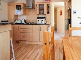 Eine moderne Küche mit Holzschränken, einem Gasherd und einem Backofen.