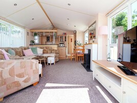 Ein kompakter Wohnraum mit Sofa, kleinem Tisch, Küchenzeile und Kamin.