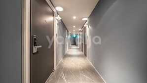 A modern hotel hallway with a marble floor and recessed lighting. - BROWN-DOT HOTEL (Busan)