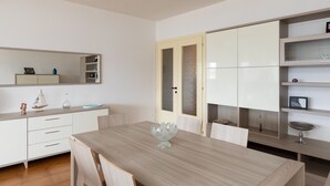 Un comedor moderno con una mesa de madera, sillas y un espejo grande arriba.
