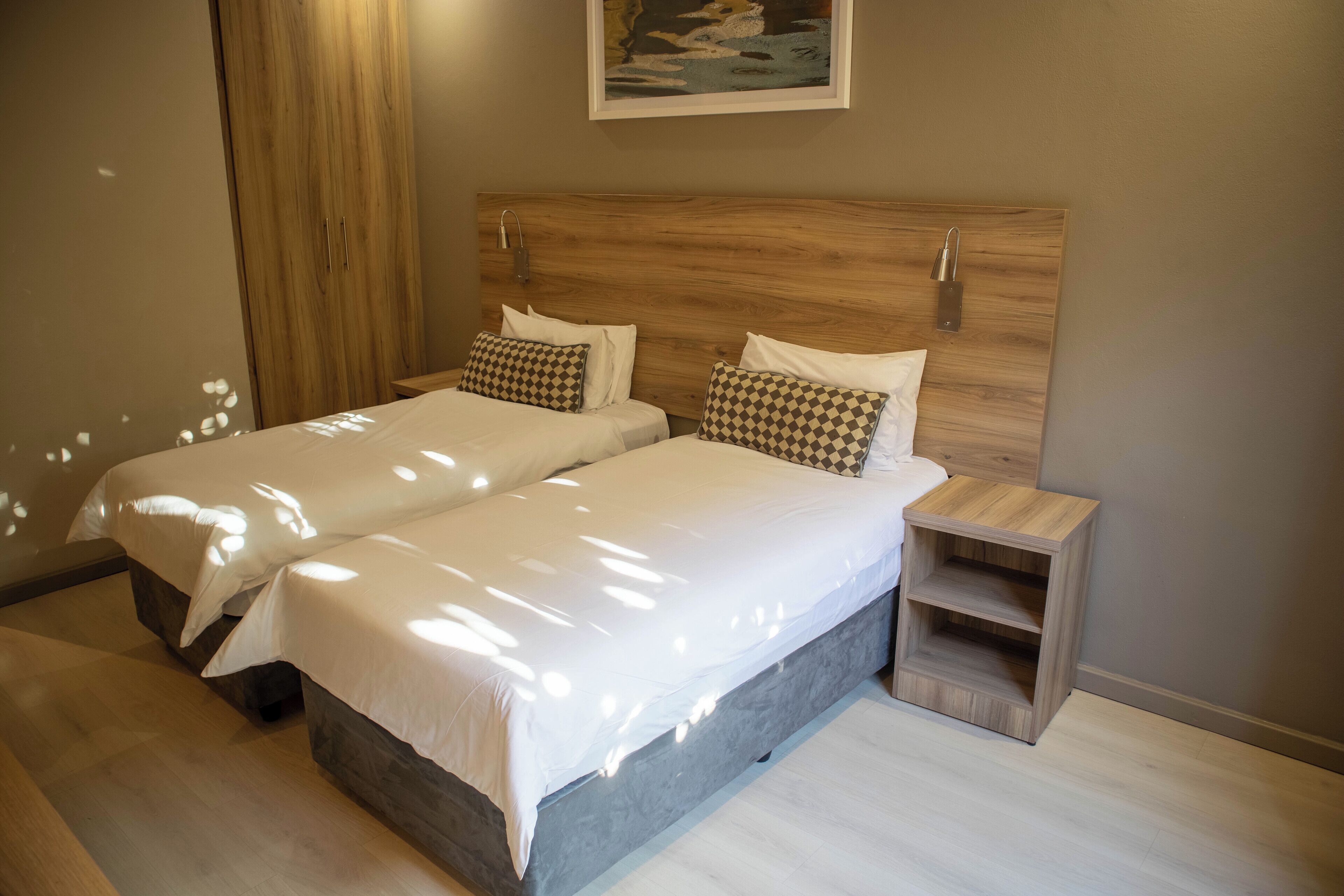 A double bed with a wooden headboard, two bedside tables, and a small wooden shelf.