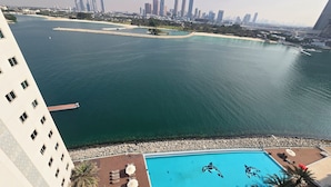 A hotel pool with dolphins, a city skyline, and a waterfront view. - Highend Azure Stay In Palm Jumeirah (Dubai)