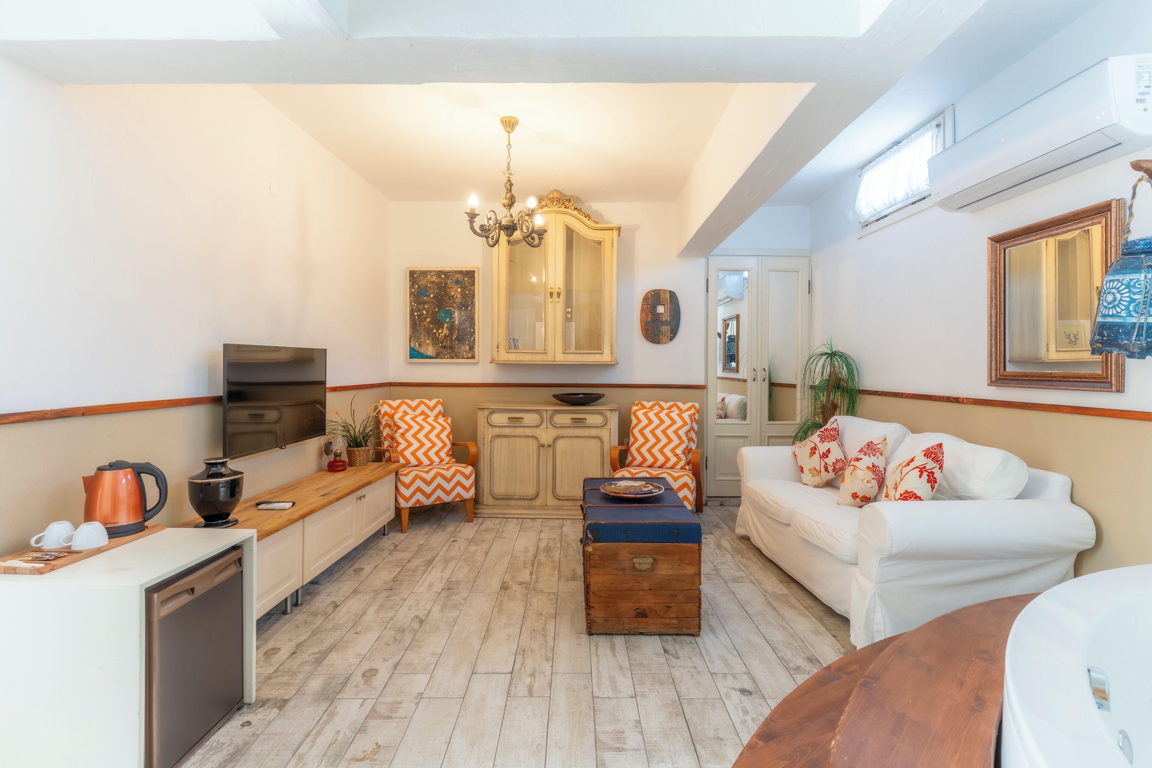 Un espacio habitable pequeño con cocina, comedor y un sofá blanco.