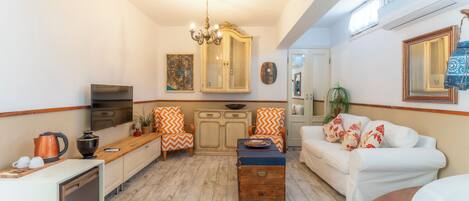 Un espacio habitable pequeño con cocina, comedor y un sofá blanco.