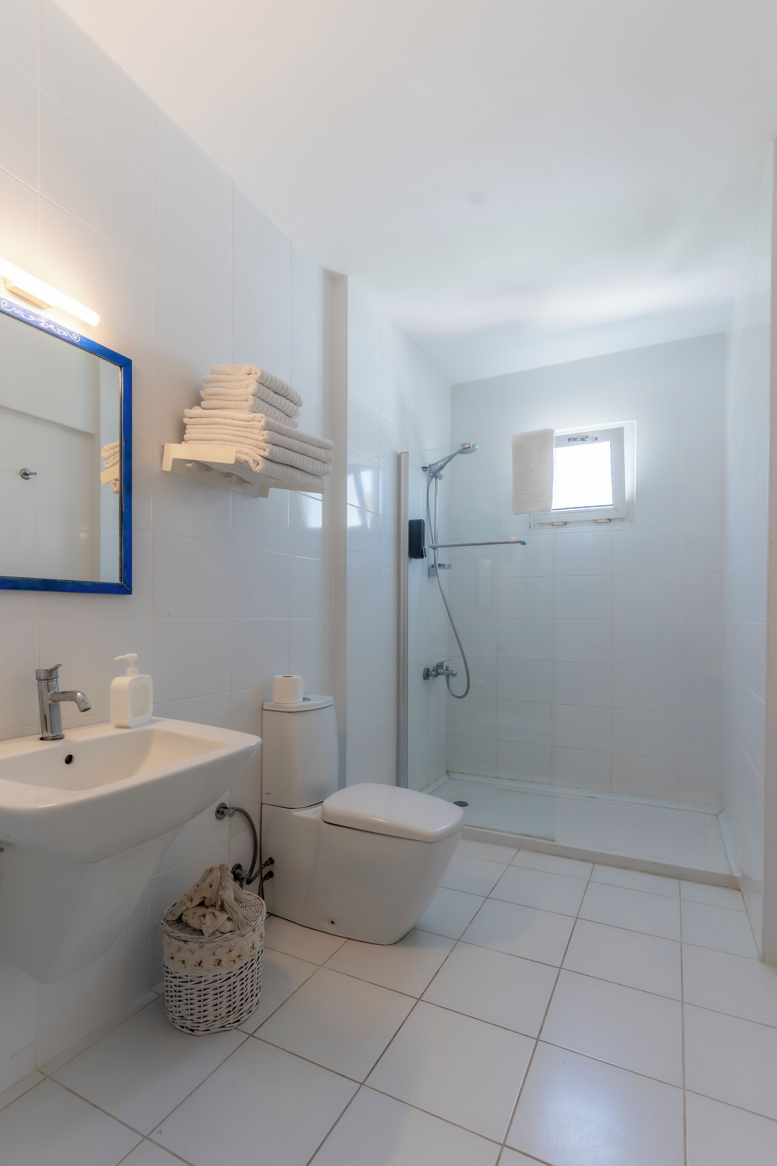 A modern bathroom with a sink, mirror, and shower.
