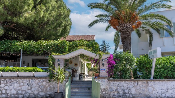 A stone-walled entrance with a covered staircase leading to a building with a tiled roof. - Mon Ilıca Otel (Cesme)