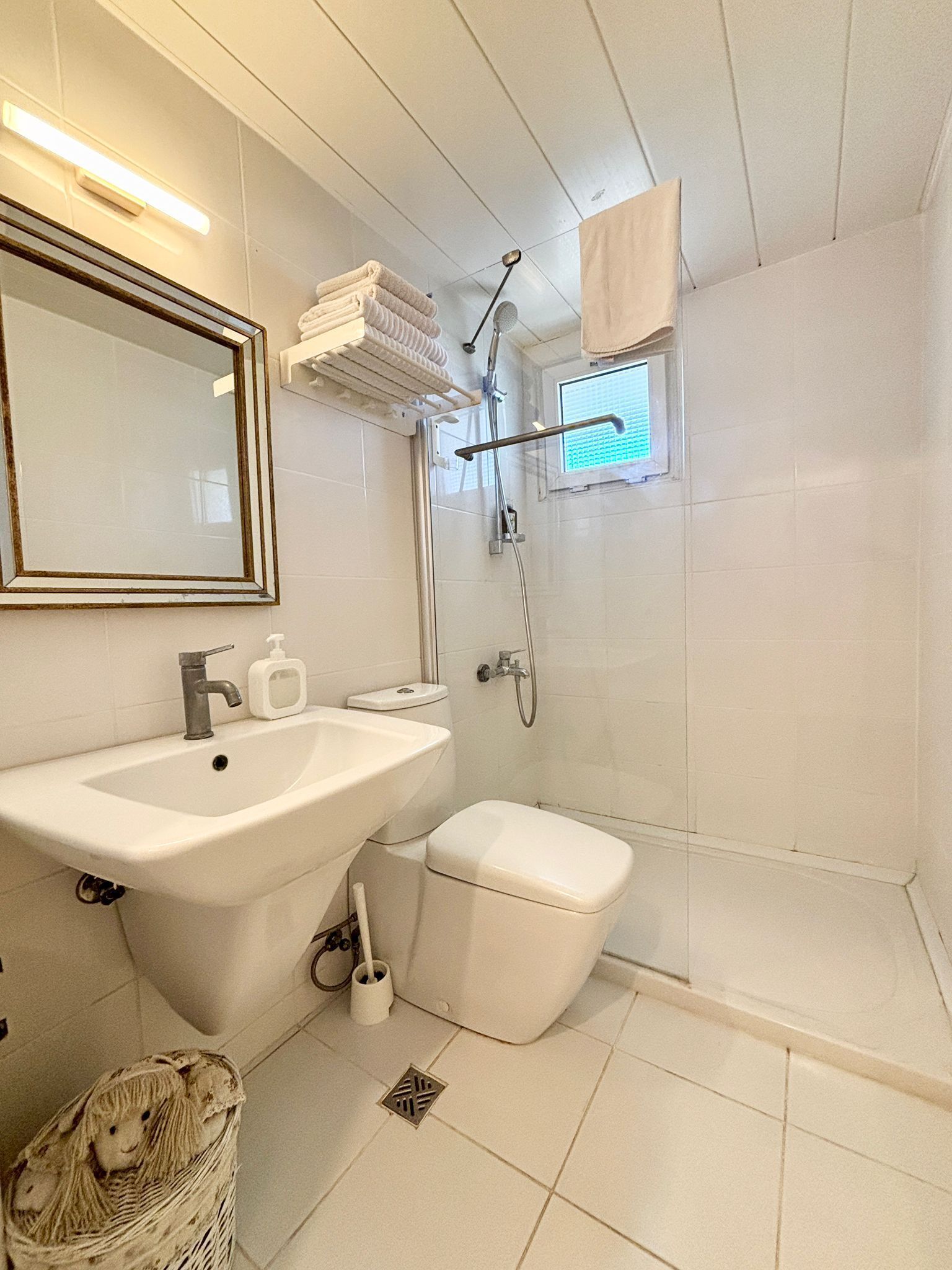 A bathroom with a sink, toilet, and shower.