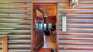 Ein Holzhütten-Interieur mit einer Holztür, die in einen Essbereich führt.