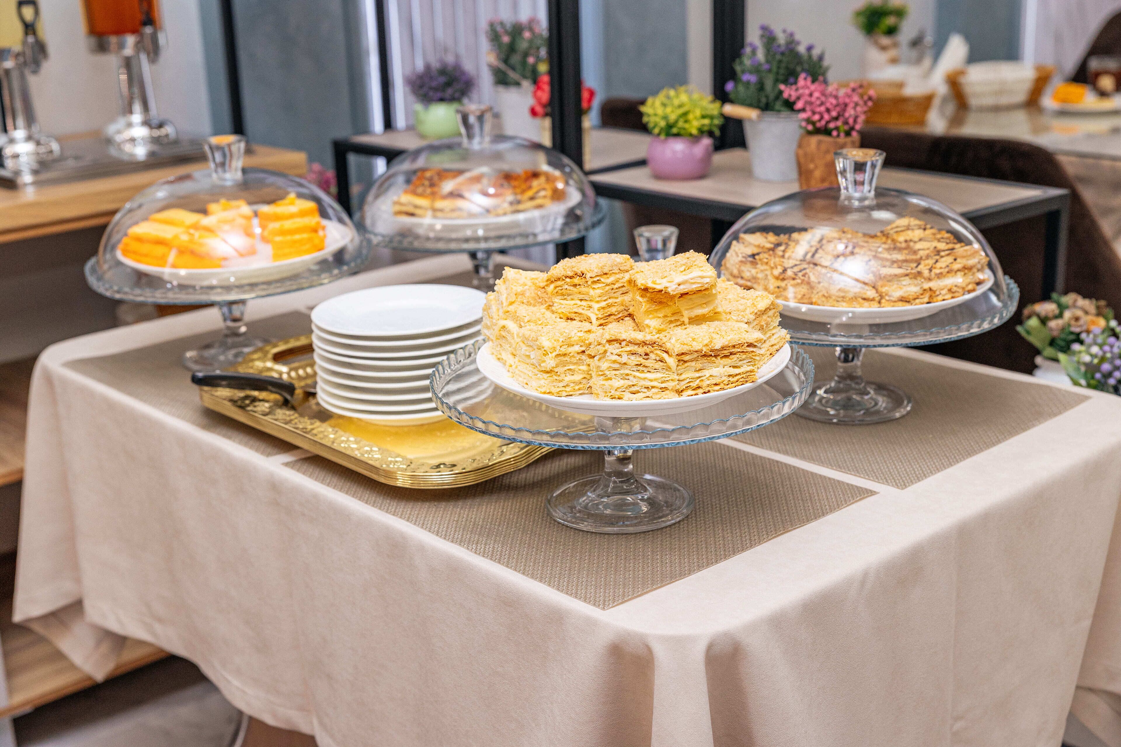 A buffet table with various desserts displayed on glass stands.